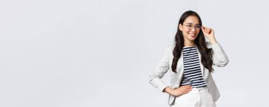 İş, finans ve istihdam, başarılı kadın girişimciler konsepti. Gözlüklü ve beyaz takım elbiseli kendine güvenen iş kadını buluşmaya hazır gülümsüyor, mutlu, kararlı.