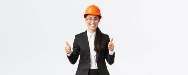 Harika iş, iyi iş. Tatmin olmuş profesyonel kadın mühendis, güvenlik kaskı ve takım elbiseli inşaat mimarı, onaylı baş parmak gösterme, satış evi reklamı, beyaz arka plan.