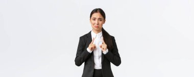 Asyalı satış elemanı küçük beden diye şikayet ediyor. Bayan ofis müdürü hoşnutsuz görünüyor ve küçük, küçük ve hayal kırıklığı yaratan beyaz bir arka plan gösteriyor.