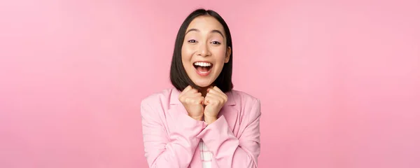 Ritratto di felice signora ufficio asiatico, amministratore delegato donna d'affari in giacca e cravatta gioire e ridere, vincere, festeggiare, raggiungere l'obiettivo e gioire, in piedi su sfondo rosa — Foto Stock