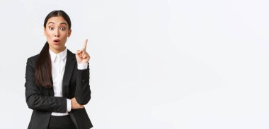 Şaşırmış zeki Asyalı kadın girişimci, inşaat müdürünün büyük bir planı var. Çözüm önermek için parmağını kaldırıyor, düşüncelerini ve fikirlerini grupla paylaşıyor, beyaz arka planda duruyor.