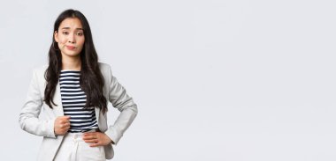 İş, finans ve istihdam, başarılı kadın girişimciler konsepti. Kibirli ve kendinden emin Asyalı genç iş kadını etkilenmemiş görünüyor, şüpheci bir sırıtış yap.