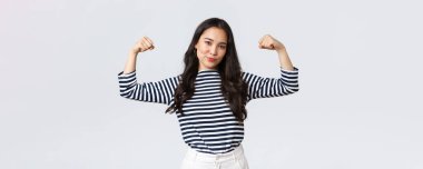 Yaşam tarzı, insanların duyguları ve gelişigüzel kavramlar. Güçlü ve kendinden emin Asyalı kadın kaslarını esnetiyor. Spor salonuna kaydolduktan sonra mükemmel vücuduyla övünüyor. Kaslarıyla, antrenmanlarıyla ve güçlü hissetmesiyle övünüyor.