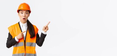 İnşaat, inşaat ve endüstriyel konsept. Asyalı kadın mühendis ilginç ürün ya da nesne hakkında sorular soruyor. Mimar sağ üst köşeyi işaret ediyor