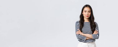 Yaşam tarzı, insanların duyguları ve gelişigüzel kavramlar. Kendine güvenen, gülümseyen Asyalı bir kadın kollarını kavuşturup kendine güveniyor, yardıma hazır, iş arkadaşlarını dinliyor, sohbet ediyor.