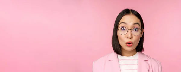 안경을 쓴 외국인 사업가의 사진을 클로즈업 한 모습, 카메라를 보고 놀란 반응, 분홍 배경 위에 양복을 입고 서 있는 모습 — 스톡 사진