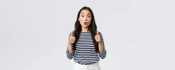 Lifestyle, beauty and fashion, people emotions concept. Surprised and amazed, excited asian girl react to wonderful performance, show thumbs-up in approval or recommendation — Stock Photo, Image