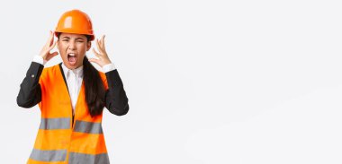 Kızgın ve öfkeli Asyalı kadın baş mühendis, inşaat müdürü öfkeden kudurdu, çalışanlara öfkelendi, bağırdı ve el sıkıştı, birini azarlarken öfkeli bir şekilde çığlık attı.