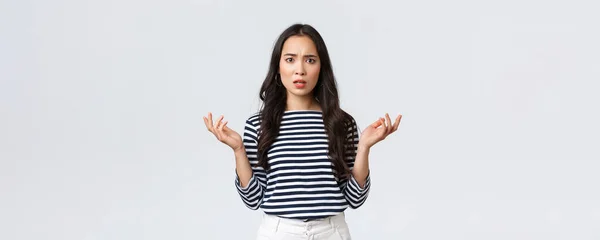 Lifestyle, mensen emoties en casual concept. Verward teleurgesteld aziatische vrouw steek de handen op in ontzetting en fronsen boos als leren schokkend slecht nieuws, cant begrijpen wat er gebeurd is — Stockfoto