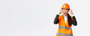 Kızgın ve öfkeli Asyalı kadın baş mühendis, inşaat müdürü öfkeden kudurdu, çalışanlara öfkelendi, bağırdı ve el sıkıştı, birini azarlarken öfkeli bir şekilde çığlık attı.