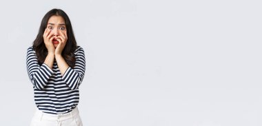 Yaşam tarzı, insanların duyguları ve gelişigüzel kavramlar. Korkmuş ürkek ve güvensiz kadın, el ele tutuşmuş, çığlık atıyor ve korkmuş görünüyor, korkudan titriyor, beyaz arka planda duruyor.