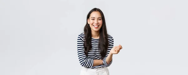 Estilo de vida, emociones de la gente y concepto casual. Despreocupado feliz extrovertido asiático mujer tener divertido hablando con la gente, riendo y sonriendo optimista, de pie blanco fondo alegre —  Fotos de Stock