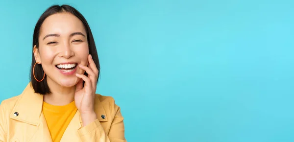Gros plan portrait de naturel asiatique fille rire, sourire et regarder heureux, debout sur fond bleu — Photo