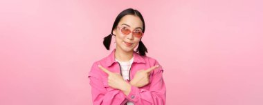Tercih. Tarz sahibi Koreli bir kız, Asyalı bir kadın model, iki farklı modeli gösteriyor, ürün reklamları, ürünleri gösteren, pembe arka planda duran