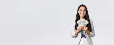 İş, finans ve istihdam, girişimci ve para kavramı. Hayalperest iş kadını nereye tatile gideceğini düşünüyor ve nasıl para kazanacağını düşünüyor, nakit tutuyor ve düşünceli bir iş kadını arıyor.