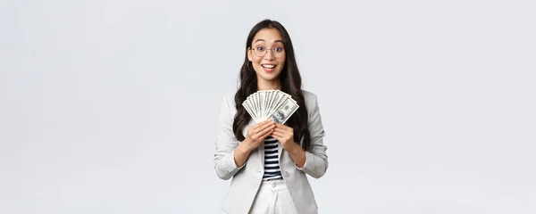 Business, finance and employment, entrepreneur and money concept. Successful young asian office manager, businesswoman showing earned cash, smiling satisfied as holding dollars — Stock Photo, Image