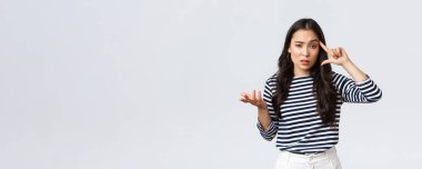 Yaşam tarzı, insanların duyguları ve gelişigüzel kavramlar. Hüsrana uğramış ve rahatsız olmuş Asyalı genç bir kadın aptalca bir hata yapıyor, parmağını şakaktan yuvarlıyor ve korkuyla elini kaldırıyor.