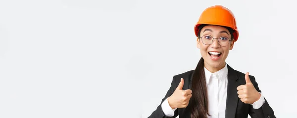 兴奋快乐的亚洲女工程师，戴着安全帽、身穿西服的施工经理喜形于色，赞许工作出色，称赞工作出色，背景洁白 — 图库照片