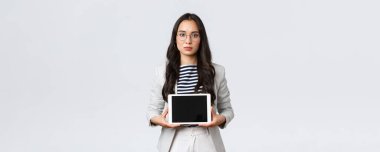 İş, finans ve istihdam, başarılı kadın girişimciler konsepti. Ciddi görünümlü ofis müdürü, Asyalı bayan çalışan dijital tablet ekranda ürününü tanıtıyor.