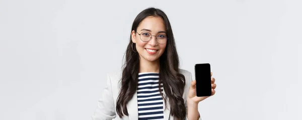 Negocios, finanzas y empleo, concepto de emprendedoras exitosas. Primer plano de elegante mujer de negocios asiática moderna introducir aplicación móvil, mostrando el anuncio en el teléfono inteligente — Foto de Stock