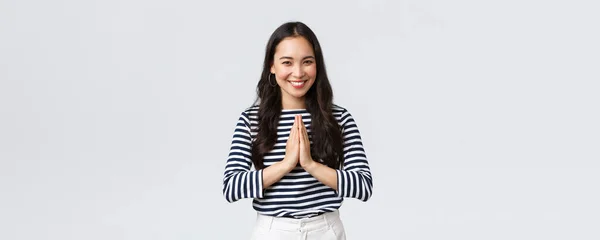 Lifestyle, people emotions and casual concept. Cute asian girl in casual outfit smiling as saying namaste, holding hands in pray, pleading or greeting guests with polite bow — Stock Photo, Image
