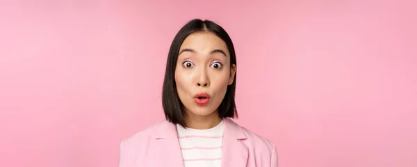 Κοντινό πλάνο πορτρέτο της ασιατικής εταιρικής γυναίκας, επιχειρηματίας κυρία αναζητούν έκπληκτος και έκπληκτος στην κάμερα, στέκεται στο κοστούμι σε ροζ φόντο — Φωτογραφία Αρχείου