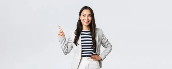 商业、金融和就业，女企业家概念。穿着白色西服的快乐成功的女商人指着左上角的手指，展示着广告 — 图库照片