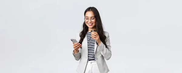 Бізнес, фінанси та зайнятість, концепція успішних жінок-підприємців. Професійна азіатська бізнес-леді в окулярах, обідаючи, випиваючи каву і використовуючи мобільний телефон — стокове фото