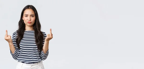 Lifestyle, beauty and fashion, people emotions concept. Pouting bothered young pissed-off asian female look annoyed and showing middle-fingers rude gesture, white background — Stock Photo, Image