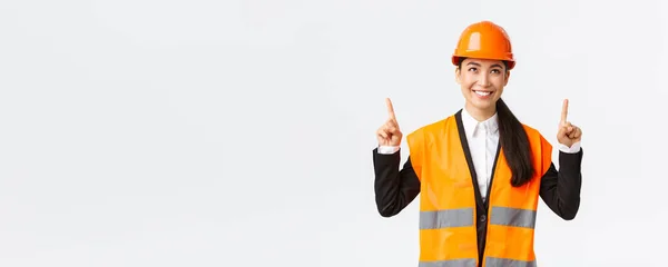 건축, 건설 및 산업 개념. 만족 한 이시아계여 직원들은 고객들에게 물건을 팔아 준다. 안전 헬멧을 쓰고 손가락을 들고 있는 기술자 나건 축가 — 스톡 사진