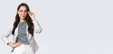 İş, finans ve istihdam, başarılı kadın girişimciler konsepti. Gözlüklü ve beyaz takım elbiseli kendine güvenen iş kadını buluşmaya hazır gülümsüyor, mutlu, kararlı.