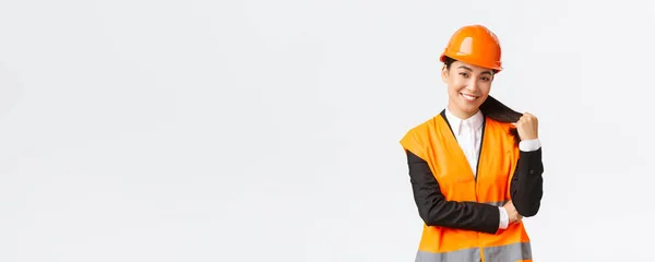 Portret van een zelfverzekerde glimlachende Aziatische vrouwelijke bouwmanager, ingenieur in de bouw, dragen van een veiligheidshelm en reflecterende jas, blij met het project, tevreden zijn met het werk — Stockfoto