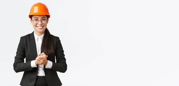 顧客や投資家に企業を紹介する安全ヘルメットとビジネススーツの笑顔のプロのアジアのビジネスマン女性,周りを示す,建設分野でプレゼンテーションを行う — ストック写真
