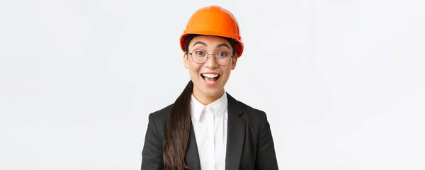 Közelkép izgatott vidám ázsiai női vezető építőmérnök, építész öltöny és biztonsági sisak mosolygott csodálkozva, látszó-val remény és elégedettség a jó munkát végzett, fehér háttér — Stock Fotó