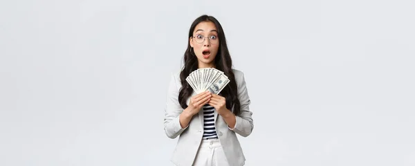 Business, finance and employment, entrepreneur and money concept. Amazed and speechless young asian businesswoman earn first paycheck for selling house, holdin cash and stare astonished — Stock Photo, Image