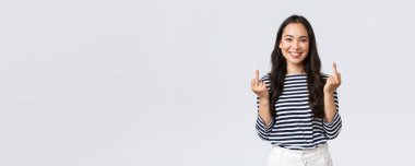 Yaşam tarzı, güzellik ve moda, insanların duygu konsepti. Rahatsız edilmemiş, dikkatsiz, mutlu, gülümseyen bir kadın. Hiç umursamaz, orta parmaklarını göstermez ve kendini iyi hisseder, beyaz bir geçmişi vardır.