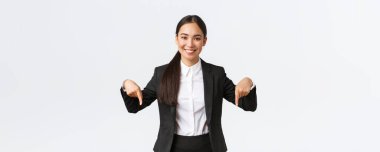 Kendine güvenen profesyonel satıcı kadın iyi bir anlaşma öneriyor, en iyi fiyatlar. Gülümseyen güzel bayan emlakçı alt reklamını gösteriyor. Takım elbiseli iş kadını parmaklarını aşağı gösteriyor.