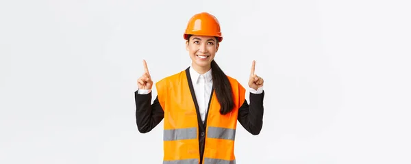 建築、建設、産業の概念。顧客オブジェクトを示す成功した女性アジアのセールスマンを満足販売のため。技術者や建築家は、安全ヘルメットを着用し、指を指して — ストック写真
