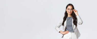 İş, finans ve istihdam, başarılı kadın girişimciler konsepti. Gözlüklü ve beyaz takım elbiseli kendine güvenen iş kadını buluşmaya hazır gülümsüyor, mutlu, kararlı.