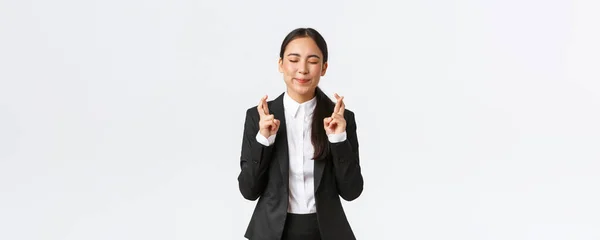 Hoopvolle optimistische zakenvrouw die vertrouwen in zichzelf, geloven dromen uitkomen, kruis vingers voor geluk en sluit ogen als het maken van wens, bidden voor genieten, witte achtergrond — Stockfoto