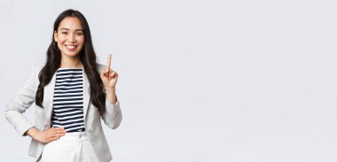 İş, finans ve istihdam, başarılı kadın girişimciler konsepti. Yakışıklı, kendine güvenen Asyalı emlakçı bir numara, iyi bir teklif sunuyor, parmağını gösteriyor ve gülümsüyor.