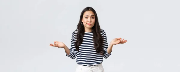 Estilo de vida, beleza e moda, as pessoas emoções conceito. Sorrindo bonito menina sem noção não tem ideia, nenhuma resposta, encolhendo os ombros com as mãos espalhadas lateralmente, de pé fundo branco — Fotografia de Stock