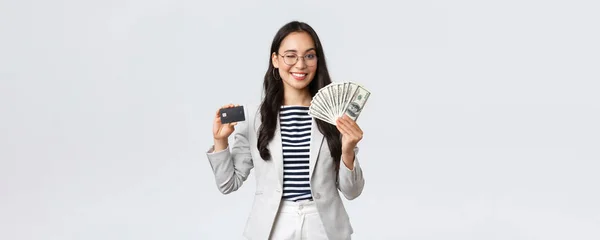 Бизнес, финансы и занятость, предприниматель и денежная концепция. Успешная азиатская предпринимательница, показывающая на курсах, как увеличить доход, держать кредитную карту и деньги, улыбающаяся камера — стоковое фото