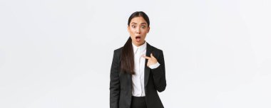 Şok olmuş ve rencide olmuş takım elbiseli genç Asyalı kadın şaşkın paniklemiş bir ifadeyle kendini işaret ediyor ve suçlanıyor. İsim verildikten sonra aşağılanmış görünen iş kadını, beyaz arkaplan