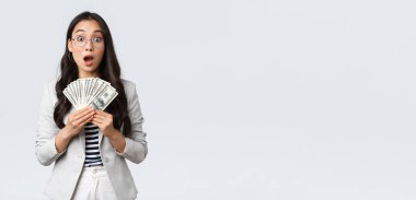 İş, finans ve istihdam, girişimci ve para kavramı. Şaşırmış ve nutku tutulmuş Asyalı genç iş kadını ev satarak ilk maaşını kazanıyor.