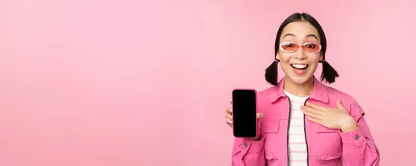 Bild av överraskad flicka visar mobiltelefon app skärm, smartphone display, ansökan gränssnitt, står mot rosa bakgrund — Stockfoto