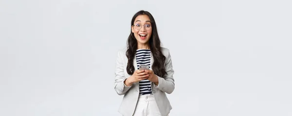 ビジネス、金融、雇用、女性の成功した起業家の概念。明るく幸せなアジアのビジネス女性,オフィスマネージャーは笑顔でupbeatカメラを見て,スマートフォンを使用して — ストック写真