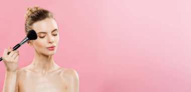 Güzellik kavramı - makyaj kozmetik toz fırçası ile uygulamak Closeup güzel beyaz kadın. Mükemmel cilt. Pembe arka plan ve kopya alanı izole.