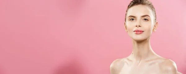 Beauty Spa koncepció - kaukázusi nő tökéletes arc bőr portré. Gyönyörű barna Spa lány mutatja a másol üres hely. Elszigetelt rózsaszín stúdió háttere. Javasolja a termék. — Stock Fotó
