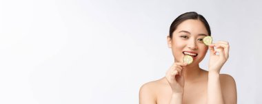 Doğal ev yapımı taze salatalık yüz göz pedleri yüz maskeleri. Asyalı kadın salatalık pedleri tutan ve gülümseme doğal ev yapımı ile rahatlayın